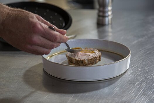 Versare il sugo sopra l'arrosto di vitello.