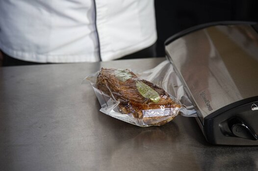 Mettere la carne di vitello sottovuoto con gli aromi e le spezie.
